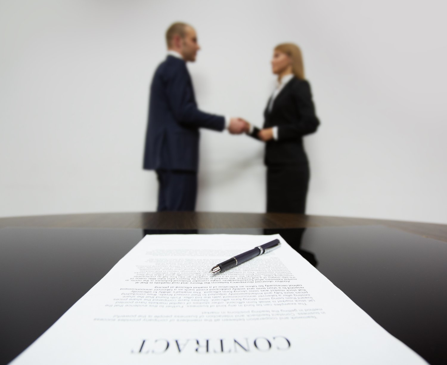 a man client and woman business consultant shaking hands in front of a government contract
